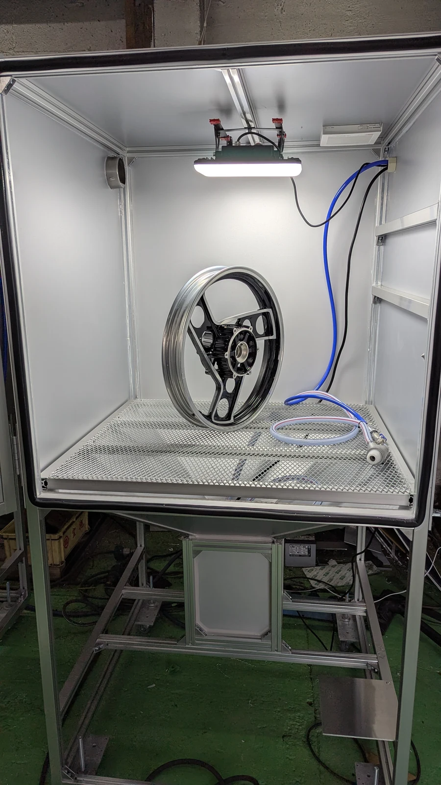 大型ウェットブラストの作業室に収めたホイール